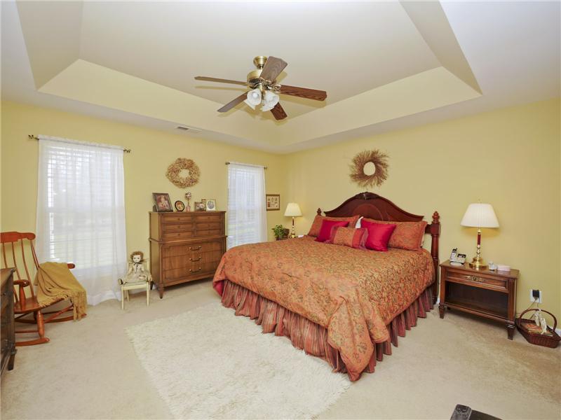 Master bedroom has tray ceiling with paddle fan