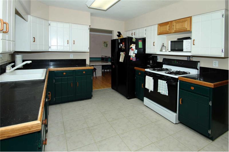 Kitchen with gas stove and tile flooring.