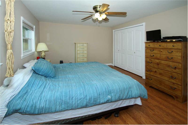 Master bedroom with ceiling fan and adjoining 3/4 bathroom