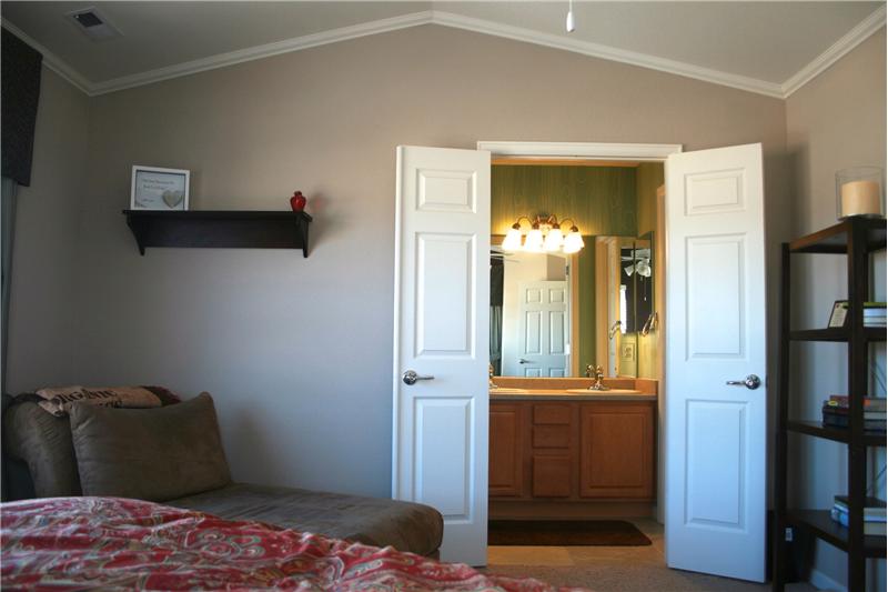 View of adjoining master bath with double doors.