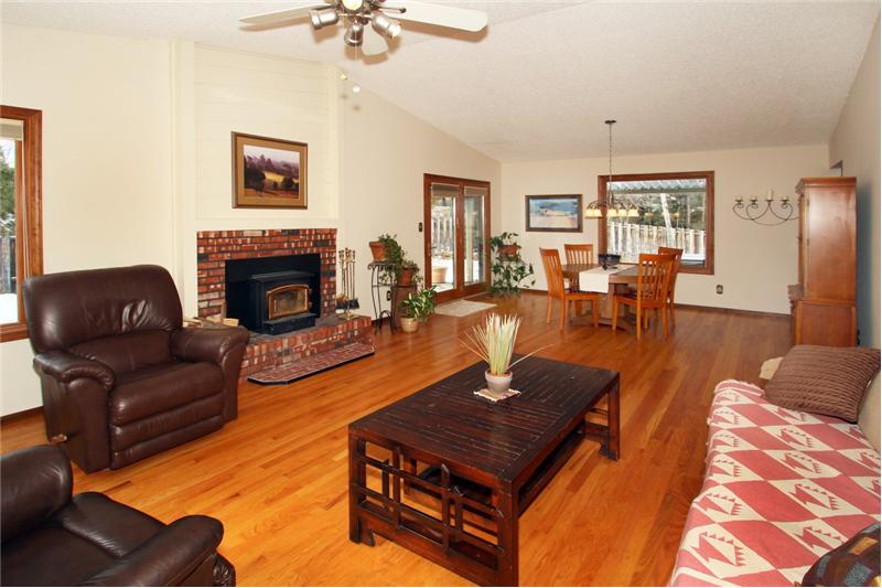 Great room is spacious and inviting with hardwood flooring and large windows