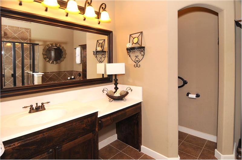 The elegantly framed mirror and lighting complete this stunning bath!