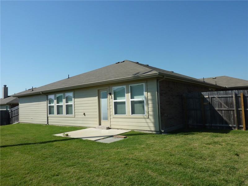 The backyard is surrounded by a wood fence.