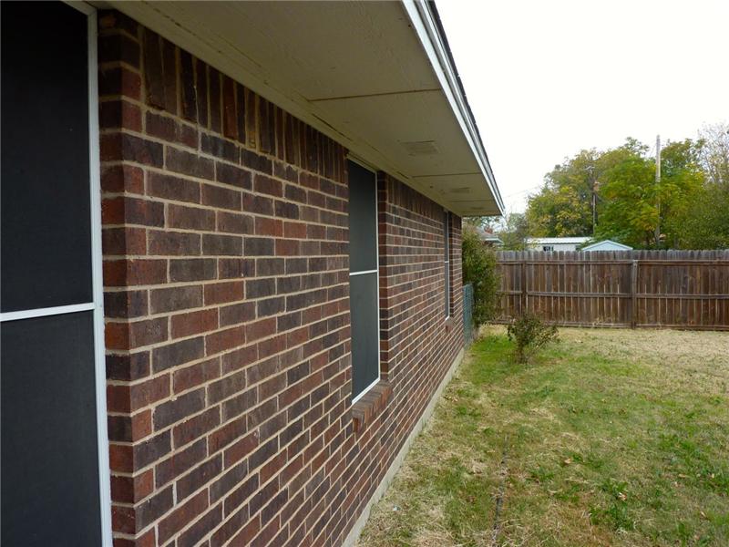 A sideview of the home shows off the solar screens and beautiful brick!