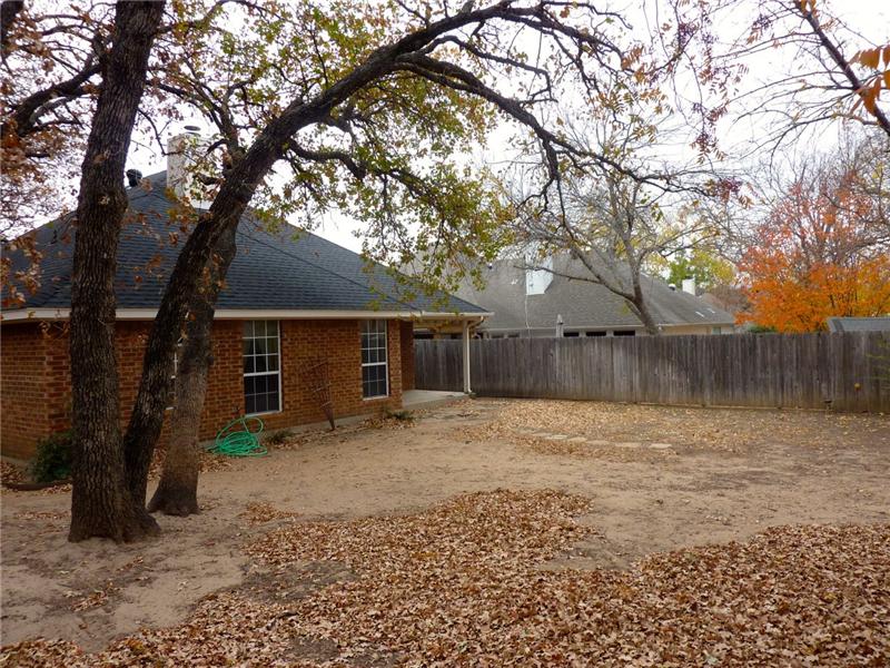 The yard is surrounded by a wooden fence.