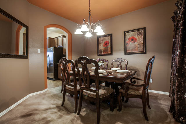 Formal dining room with decorative lighting.
