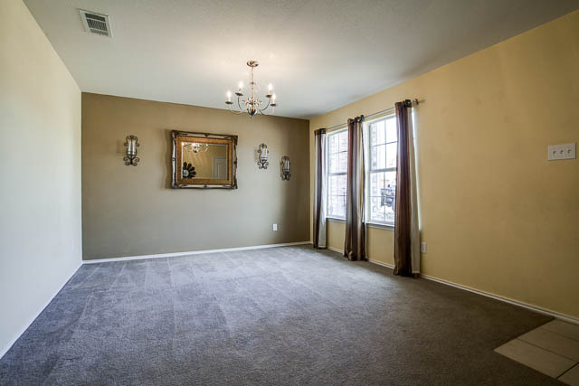 Notice the decorative lighting fixtures and beautiful natural light in the formal room.