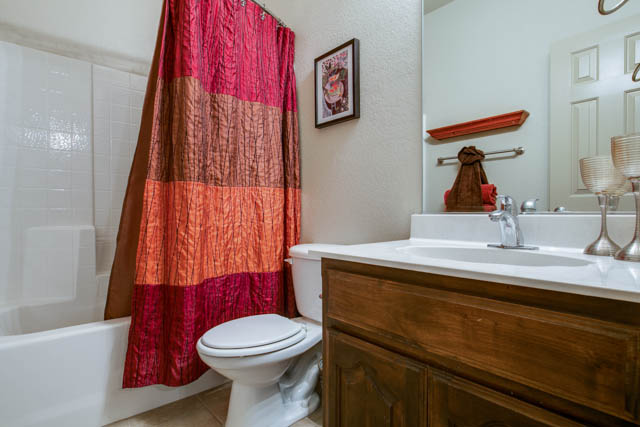 Two full bathrooms and a utility room with shelves are featured in the home.