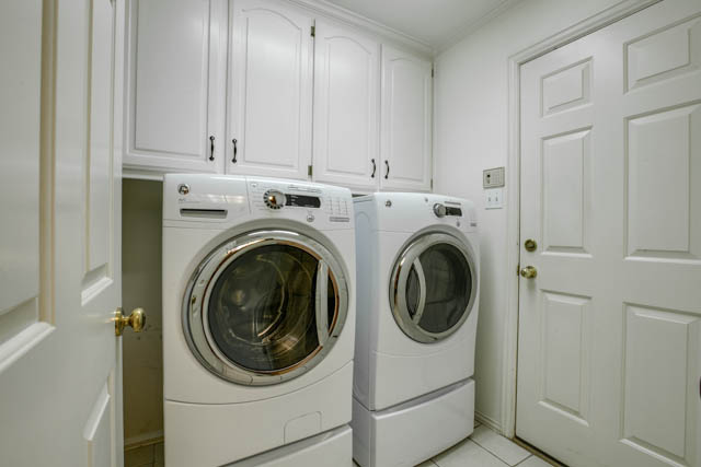 The laundry room is just off the kitchen and offers built in cabinets for easy storage.