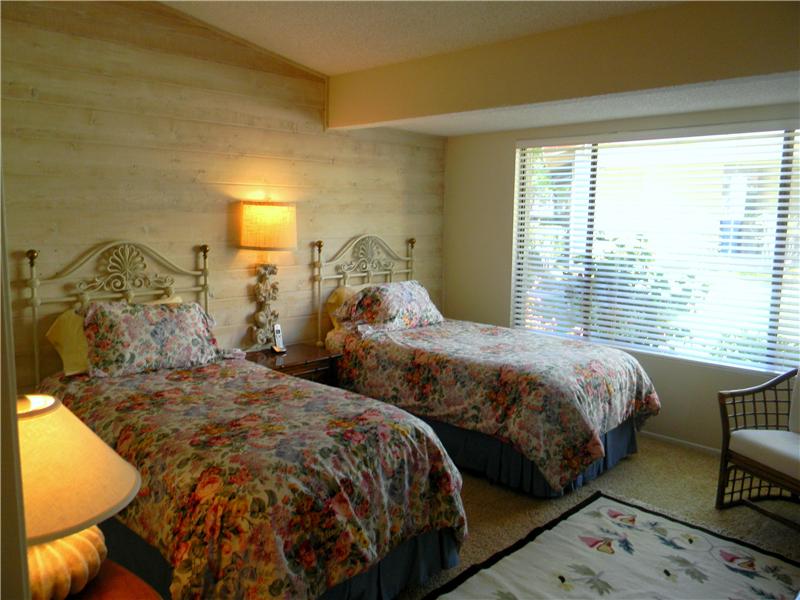 Large guest room with vaulted ceiling and wall of wood paneling