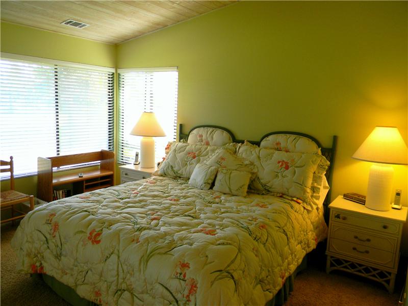 Master bedroom features wood vaulted ceiling and fresh paint