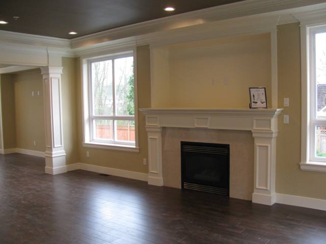 Great room showing pot lights, laminate floors and detail workmanship with crown mouldings and baseboards